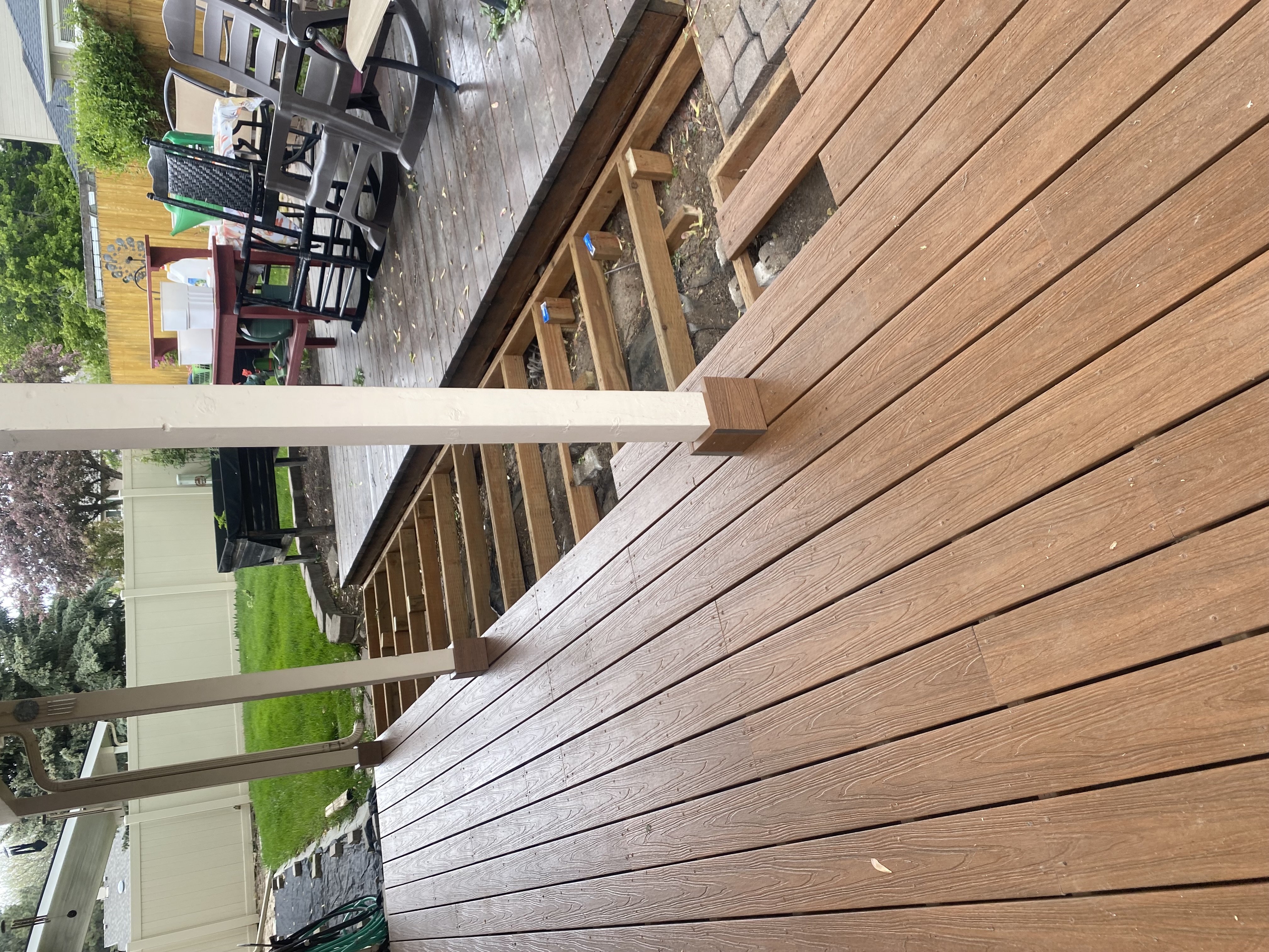 Deck replacement in progress showing new composite decking next to old wood deck