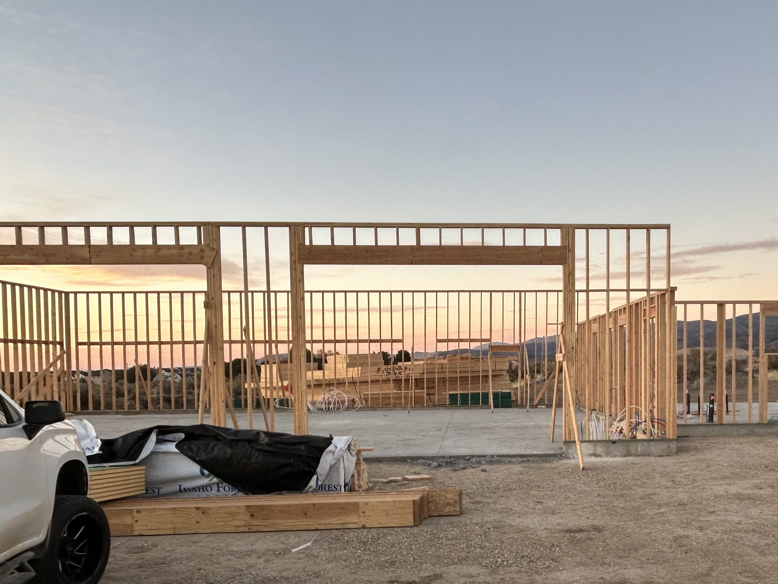 Wall framing for a new build at sunset across a concrete slab
