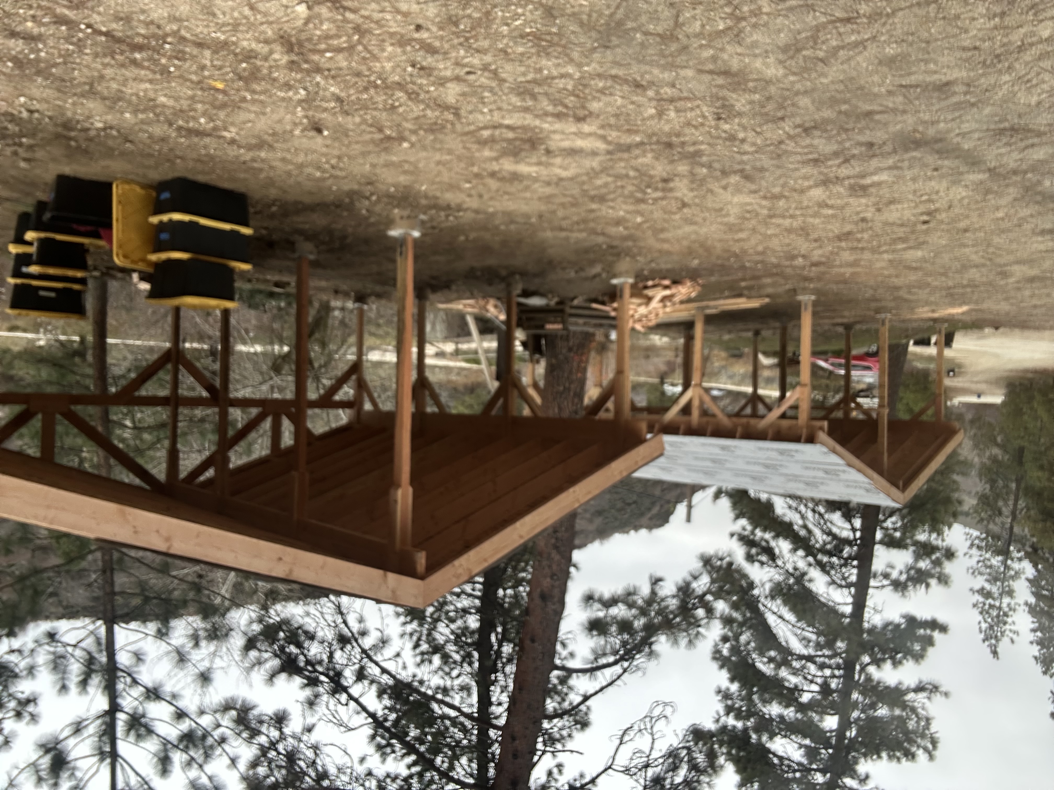 Multiple timber shelters built in a wooded campground