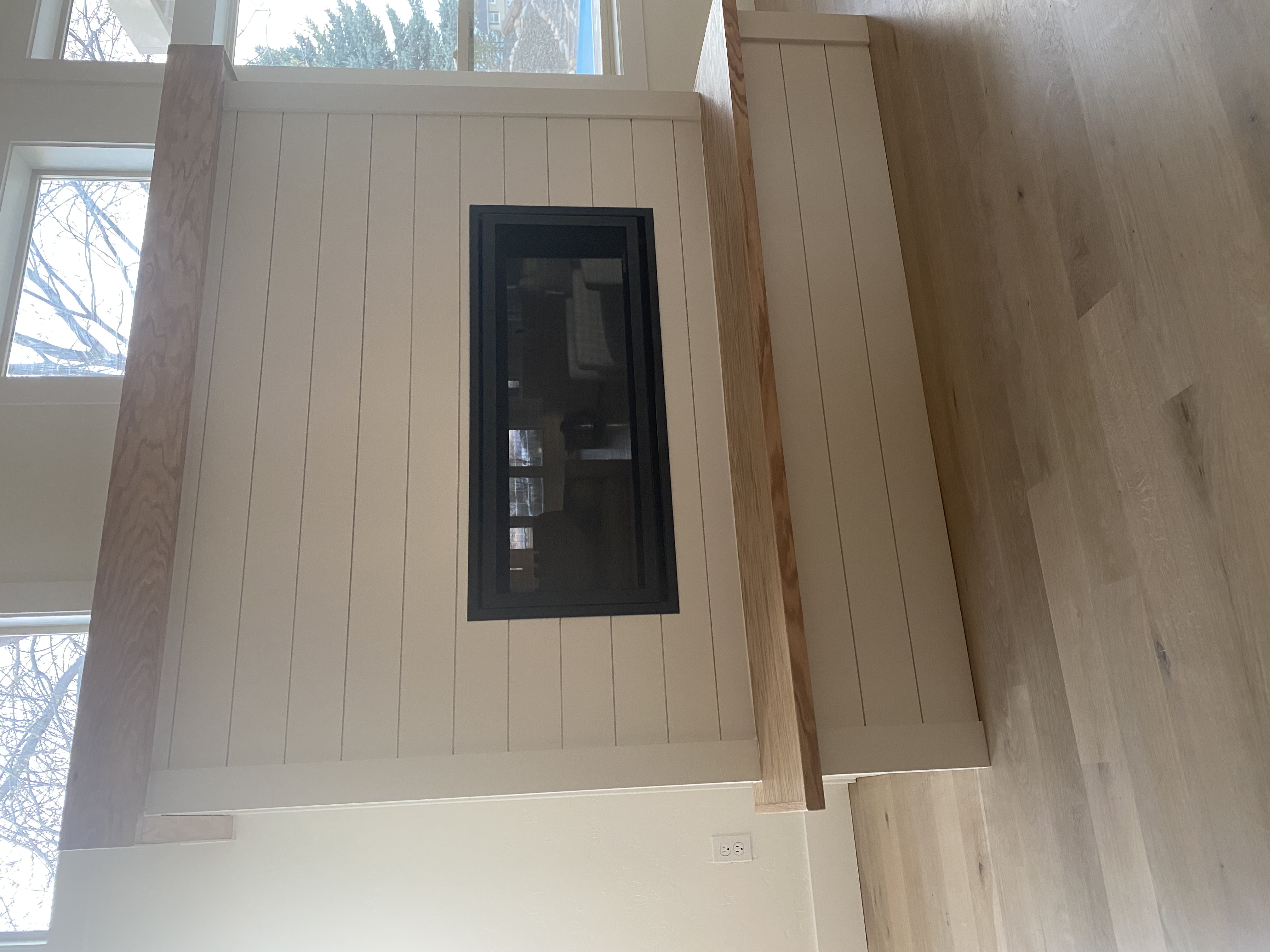 Close-up of custom shiplap fireplace surround with solid wood bench